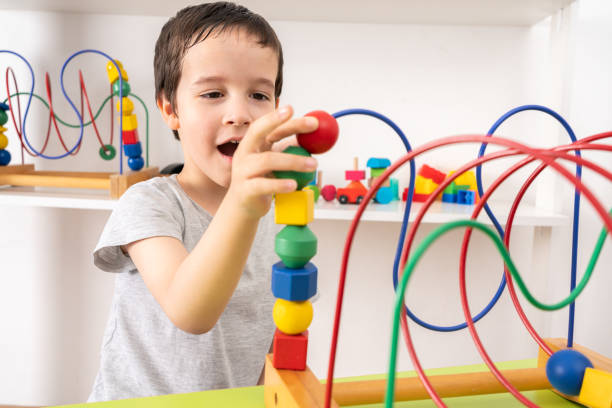 istock little boy playing with a wooden rollercoaster maze 1435785387