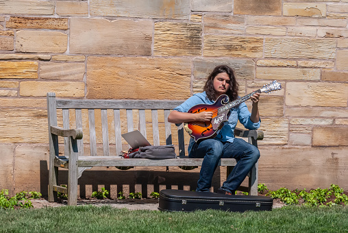 New Haven, Connecticut, United States of America - April 28, 2017. Musician playing guitar in front of Berkeley College of the Yale University in New Haven, CT.