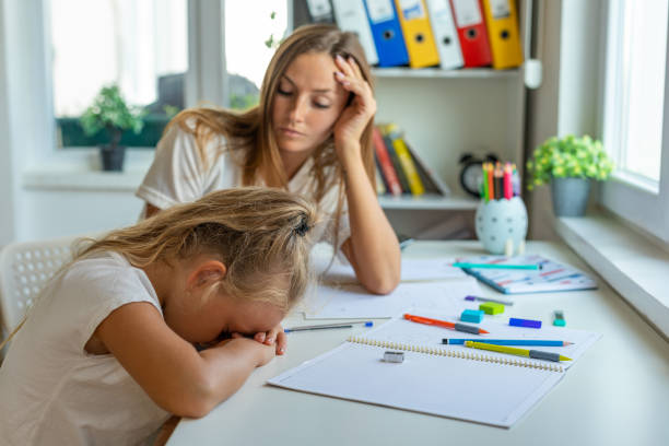ストレスを抱えた母と娘は宿題の失敗に苛立ち - learning boredom studying child ストックフォトと画像