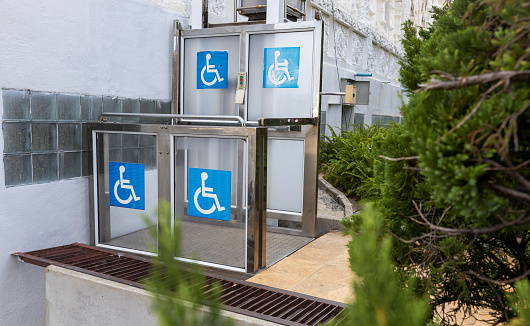 Accessible Elevator with sign. Disabled persons lift near modern apartment facility. The special elevator for the disabled at the entrance to the living house. Equipment with the wheelchair.