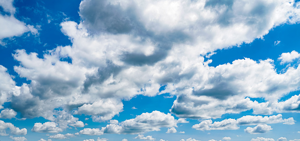Panoramic image of white clouds in a blue sky in summer.