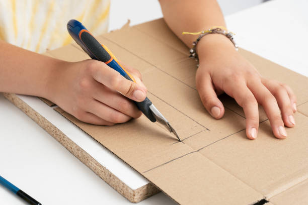 istock Woman's hands doing crafts cutting cardboard with a cutter 1435813597