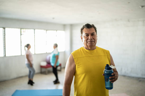 porträt eines reifen mannes mit einer wasserflasche im fitnessstudio - mexico only men senior men mature men stock-fotos und bilder