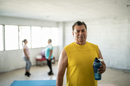 Portrait of mature man with a water bottle at the gym
