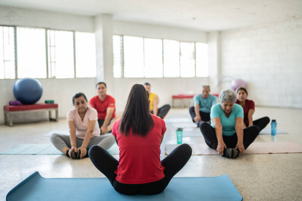 istock Yoga instructor stretching with students at the studio 1435830050