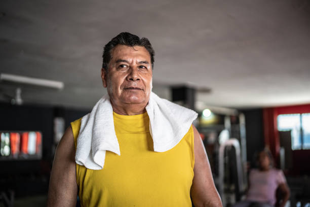 Mature man with a strong physique smiling at the camera, promoting active fitness, health, and a healthy lifestyle
