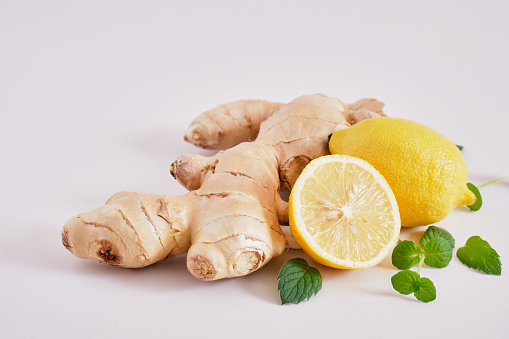 ginger root, mint leaves and lemons on a gray background, health benefits of ginger, natural drink for immunity copy space