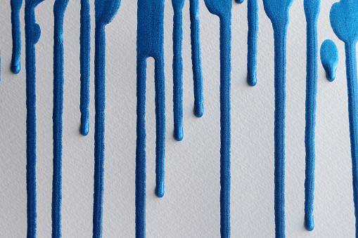 Blue paint leaking art on white paper background