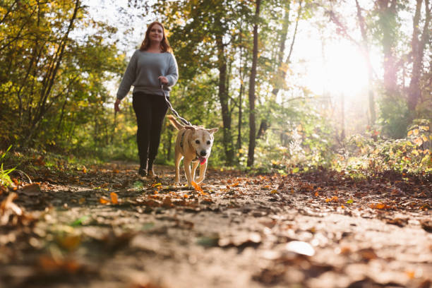 istock dog walk: young redhead woman with mixed-breed dog 1435838218