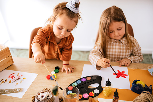 Sisters draw with water colors at home