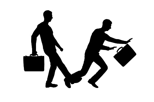 Vector silhouette of two men. One man stumbles on the other's leg. Business concept of meanness and treachery