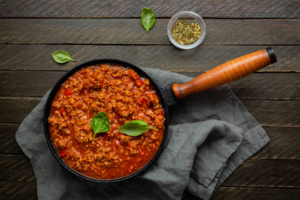 istock Overhead view of red meat sauce in skillet pan on textile rustic 1435843192