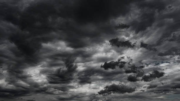 istock dark dramatic sky with black stormy clouds before rain or snow as abstract background, extreme weather, the sun shines through the clouds, high contrast photo 1435844751