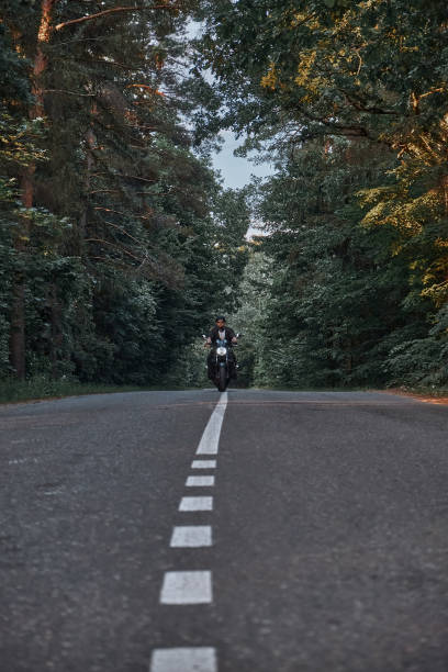 istock Blurred Motion A young man biker in a helmet quickly rides at high speed on a forest road, in motion 1435853721