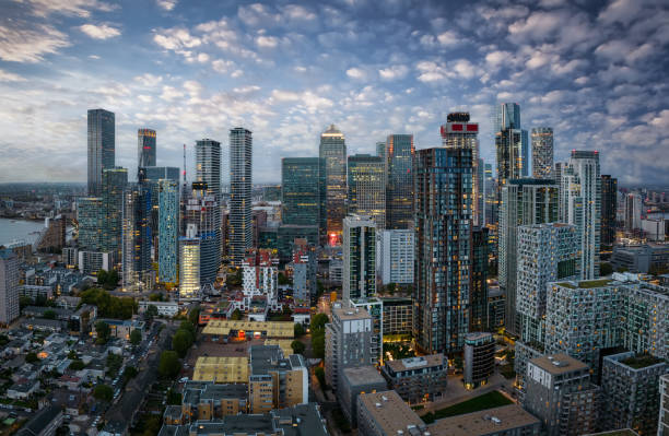 vista panoramica dei grattacieli illuminati, residenziali e aziendali di canary wharf, londra - canary wharf foto e immagini stock