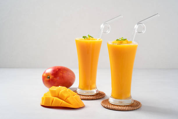 istock Fresh beautiful delicious mango juice smoothie in glass cup on gray table background. 1435860119
