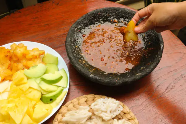 Photo of Hand pick starfruit of Lotis buah or rujak. fruits with hot chili paste and chips or kerupuk. indonesian traditional fruit salad