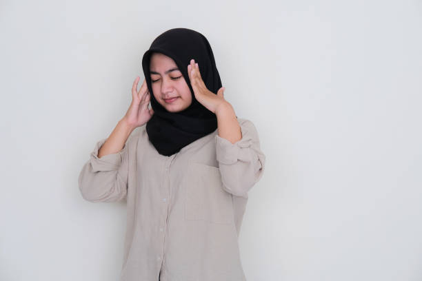 asian young girl wearing hijab touching her head showing stressed expression - pusing imagens e fotografias de stock