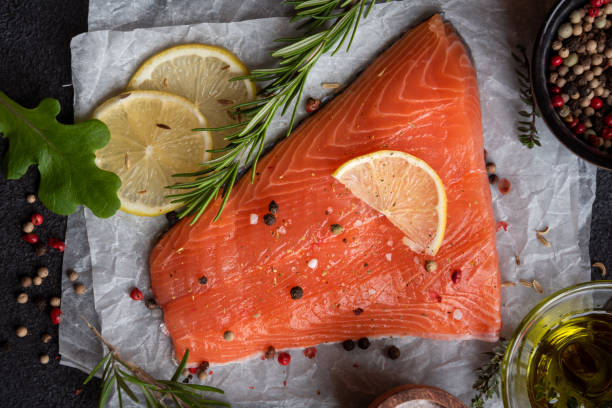 istock Uncooked raw salmon fish with herbs on dark background 1435867083