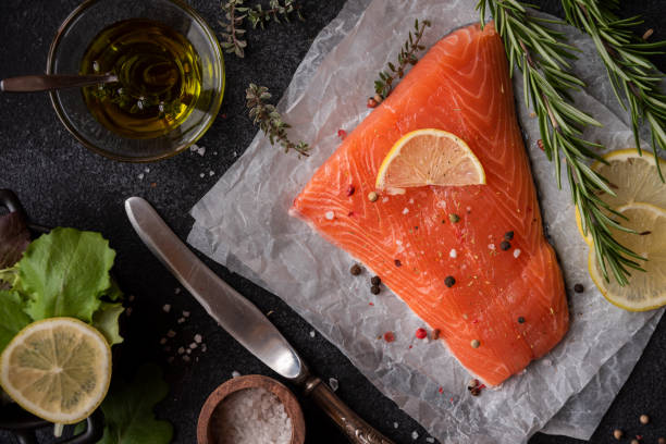 istock Uncooked raw salmon fish with herbs on dark background 1435867243