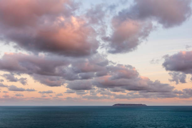 magnifiques formations nuageuses au lever du soleil et couleur sur l’île lundy sur la côte du devonshire en angleterre à la fin de l’été - hartland point lighthouse photos et images de collection