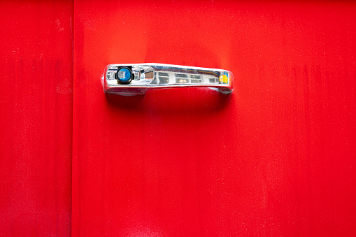 Chrome door handle on red background