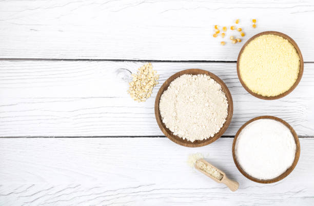 an assortment of alternative, gluten-free flours. baking ingredients background: gluten free rice, corn, oatmeal on a white wooden background,. copy space, top view. - gluten allergy imagens e fotografias de stock