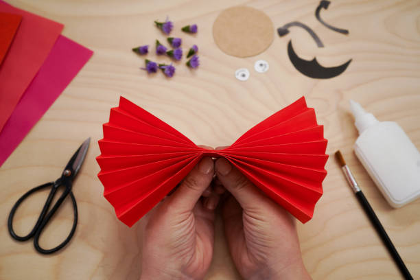 istock Step by step diy process handmade craft Ladybug made of paper and flowers. Step 3- glue the resulting accordion in the middle. Red love symbol. 1435874626