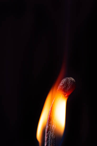 istock Matchstick burning in detail seen through a macro lens, black background, selective focus. 1435877524