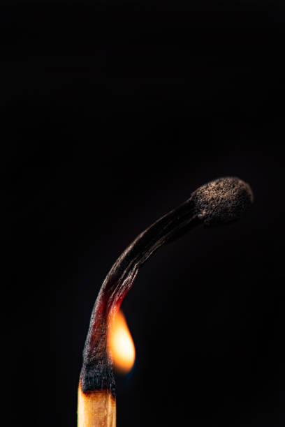istock Matchstick burning in detail seen through a macro lens, black background, selective focus. 1435877535