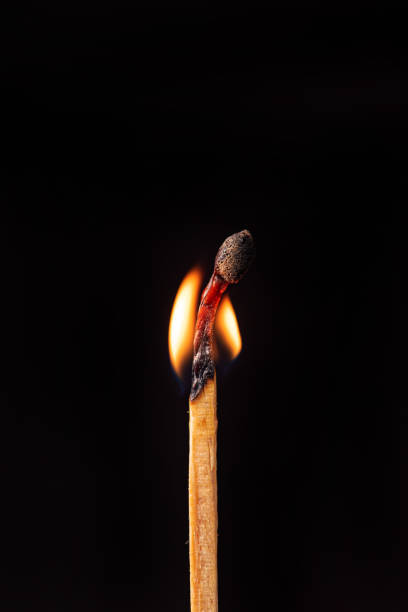 istock Matchstick burning in detail seen through a macro lens, black background, selective focus. 1435877582