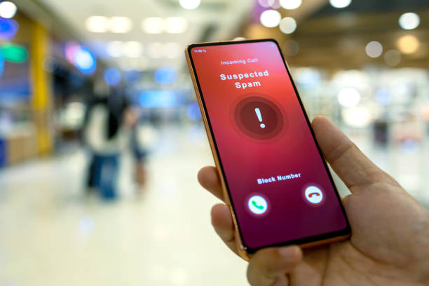 Person receiving suspected spam call on smartphone from an unknown caller in a shopping mall stock photo