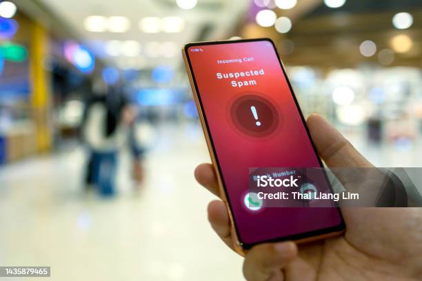 Person Receiving Suspected Spam Call On Smartphone From An Unknown Caller In A Shopping Mall Stock Photo - Download Image Now