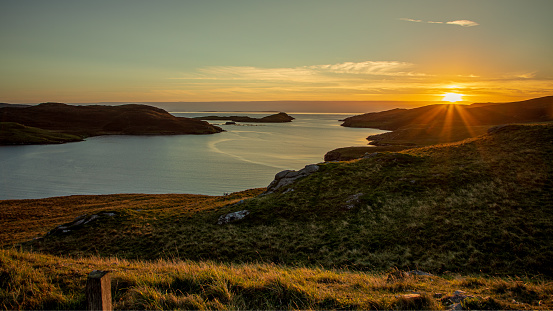 The sun sets over the dramatic landscape of Shetland