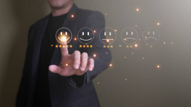 istock Selective focus at finger of business man while point finger to choose feedback on excellent customer service with five star score with smile. Service evaluation concept with futuristic icon. 1435881100