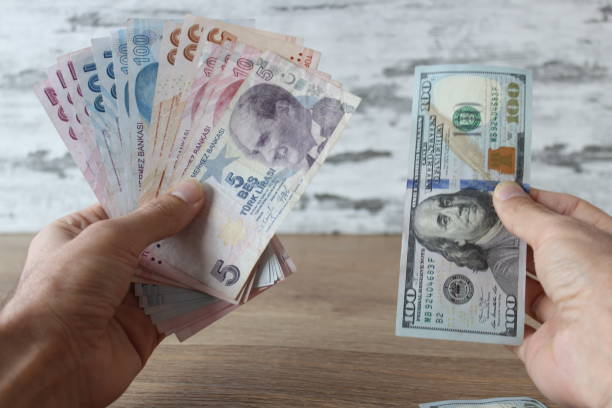 istock Exchange concept idea. Change money, man holding dollars and turkish liras with his hands. 1435881607