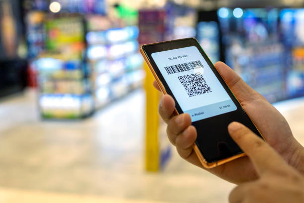 istock Cropped image of man using mobile phone making contactless payment with QR code in a shopping mall 1435881680