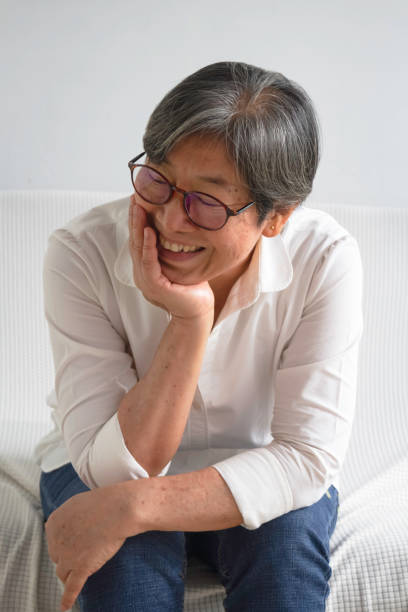 istock Old smart lady doing activity for relax time at living room 1435882404