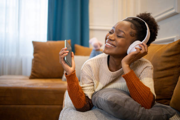 Portrait of a beautiful young woman listening to music stock photo