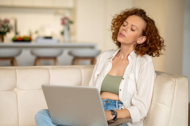 istock Ginger young woman sitting in the kitchen and working on a laptop 1435887029