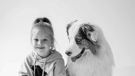 little Girl with red hair 4-5 years old and a big kind Australian Shepherd Dog