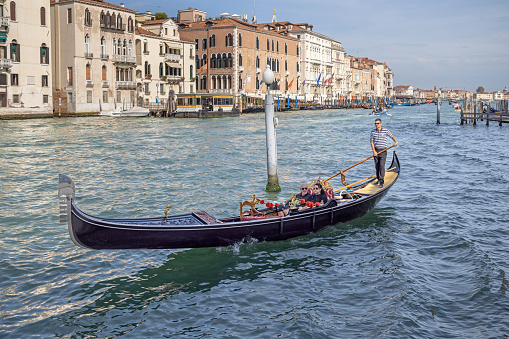 Venice, Italy - October 8th 2022: Tourists in a gondola at Canal Grande in the center of Venice