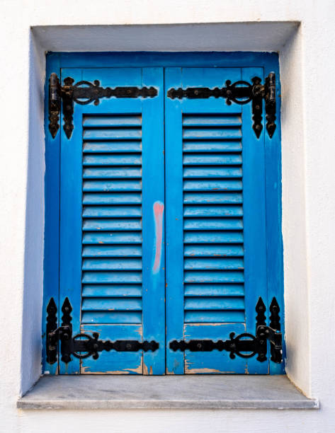istock Blue weathered shutters on a white building 1435887945