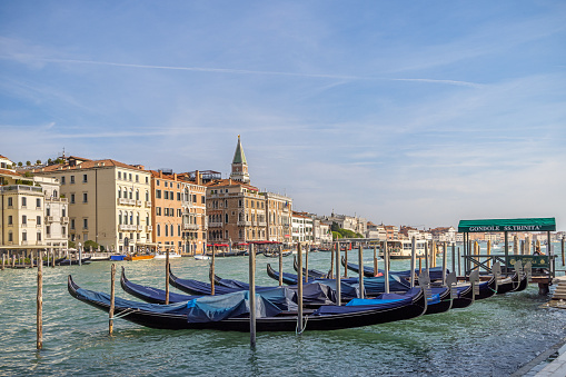Venice, Italy – September 19, 2022: An array of boats is docked on the edge of a bustling town square, providing a picturesque view of the local area