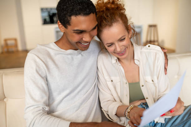 istock Two young people sitting on the sofa and choosing something online 1435889967