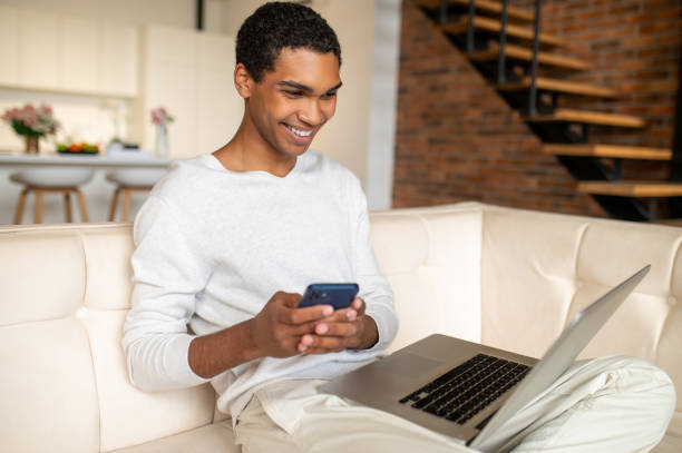 istock Young handsome dark-skinned man with a laptop 1435890794