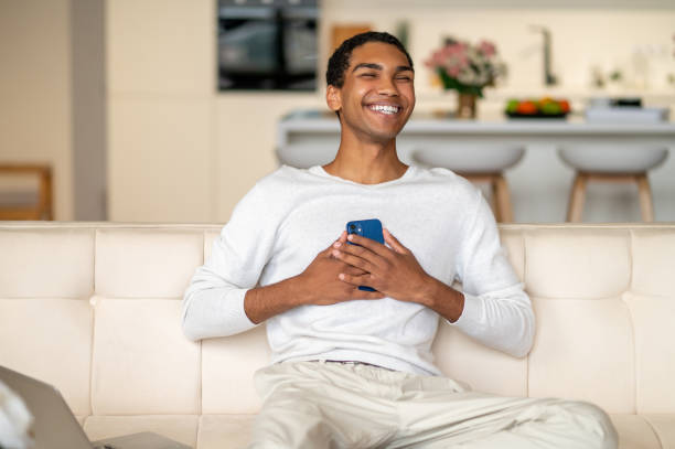 istock Young black man with a smartphone in hands looking happy 1435890853