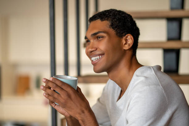 istock Young smiling man at home having coffee and looking contented 1435890961