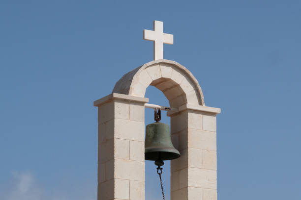 Greek Church Bell in Arch Against Blue Sky Greek bell tower above church greek orthodox stock pictures, royalty-free photos & images