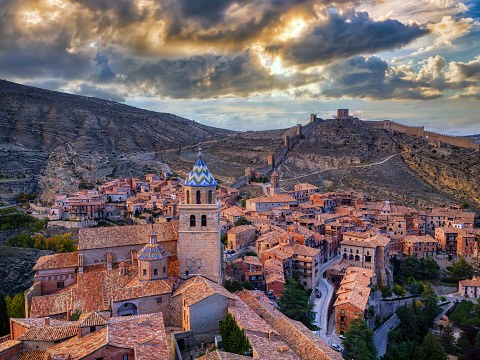 Views of Albarracin at sunset with its walls and its cathedral in the foreground.